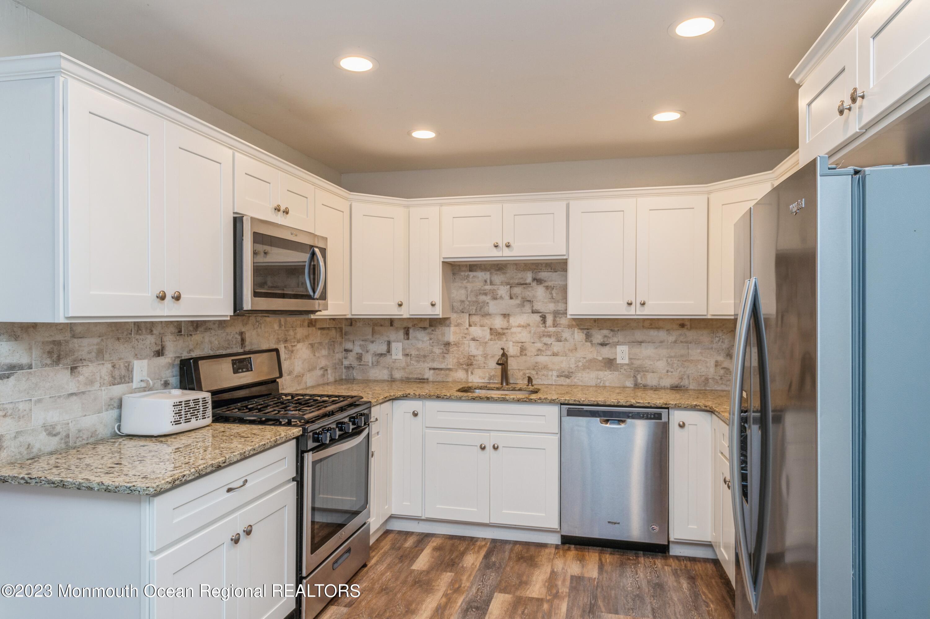121 Darien Road Howell, NJ 07731 - Photo 3 of 19 a kitchen with stainless steel appliances granite countertop a sink and cabinets