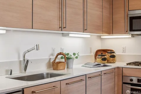 a kitchen with stainless steel appliances granite countertop a sink a stove and cabinets