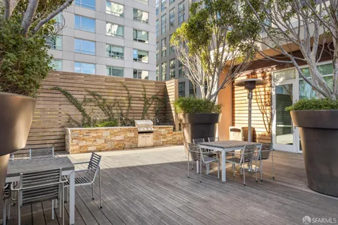 a view of a patio with table and chairs and wooden fence