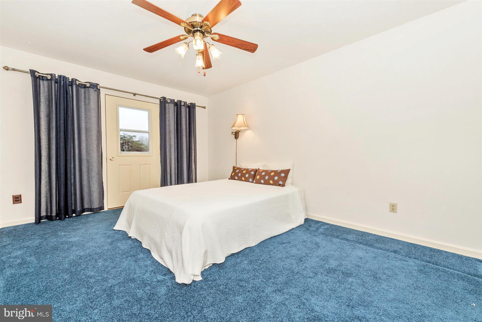 10823 Shanktown Road Big Pool, MD 21711 - Photo 22 of 30 a spacious bedroom with a bed and a chandelier