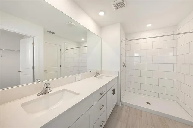 a bathroom with a bathtub shower sink double and mirror