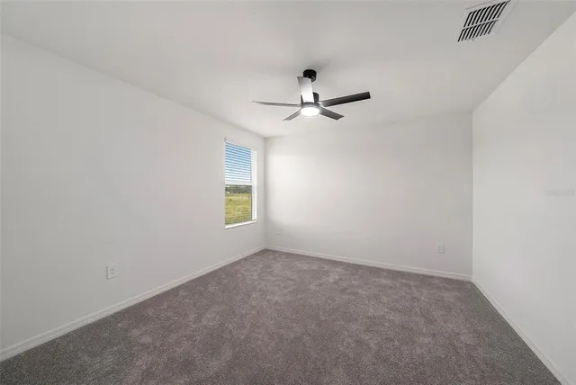 a view of room with a ceiling fan and window