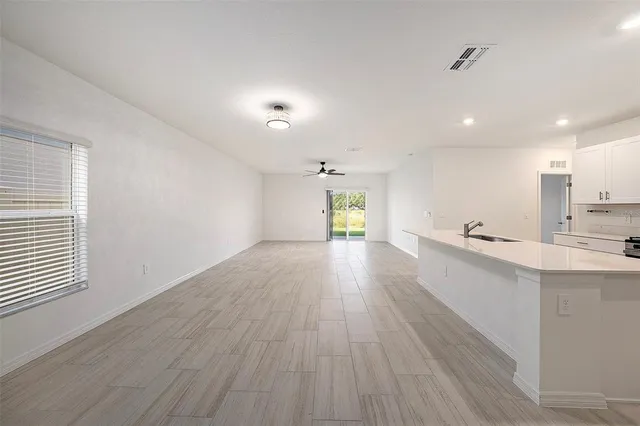 a view of a kitchen with wooden floor and windows