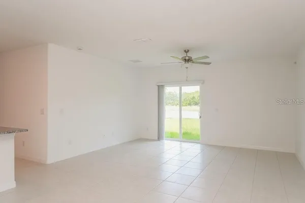 an empty room with a window and a ceiling fan