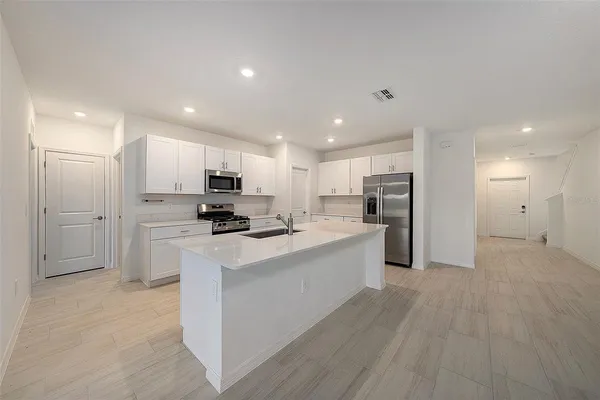 a kitchen with stainless steel appliances kitchen island sink stove and refrigerator