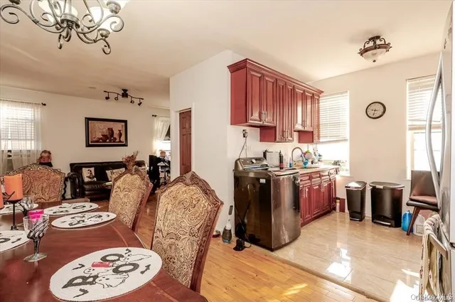 a living room with couches and kitchen view with wooden floor