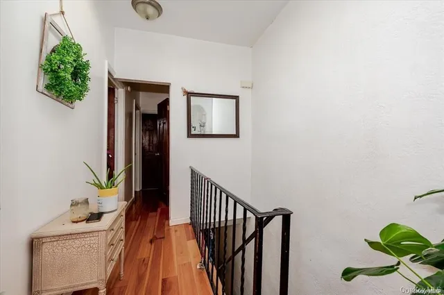 a view of a hallway with wooden floor and a potted plant