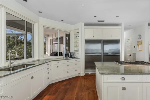 a kitchen with granite countertop a sink and cabinets