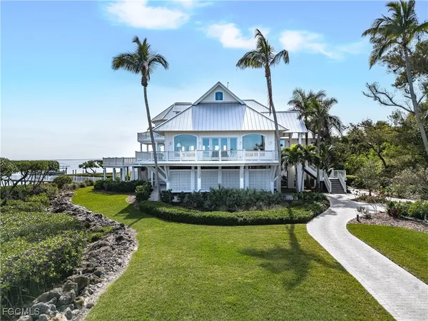 a front view of a house with a garden and lake view