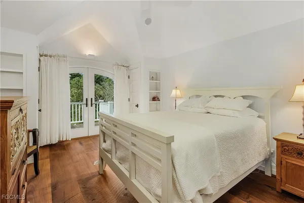 a spacious bedroom with a bed and a flat tv screen on the dresser