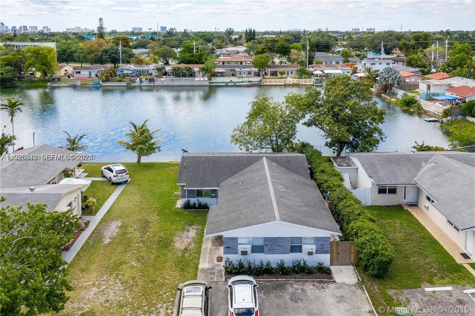an aerial view of a house with swimming pool and lake view