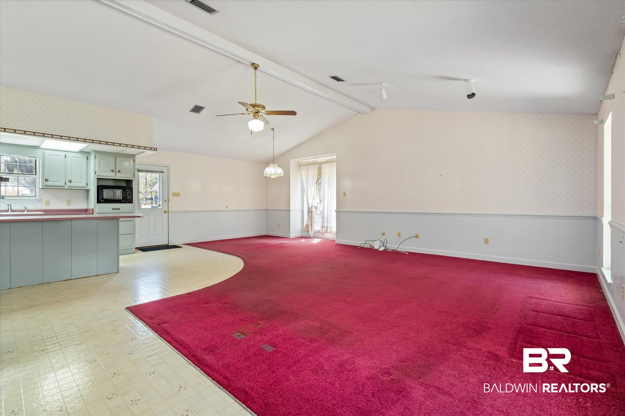 6030 Lott Road Eight Mile, AL 36613 - Photo 3 of 21 Unfurnished living room featuring a ceiling fan, wallpapered walls, a wainscoted wall, and lofted ceiling with beams