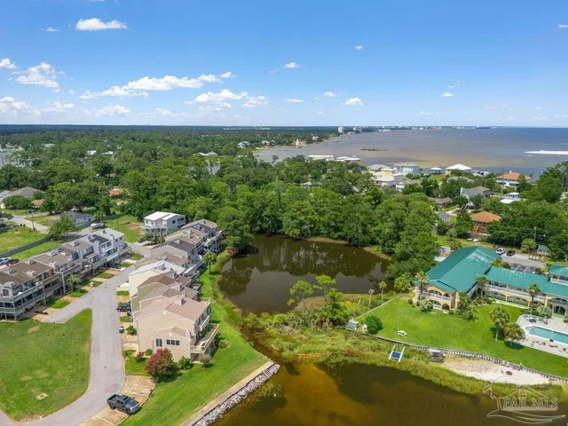 an aerial view of residential houses with outdoor space and lake view