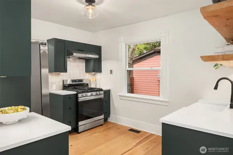 a kitchen with stainless steel appliances a stove a sink and a refrigerator