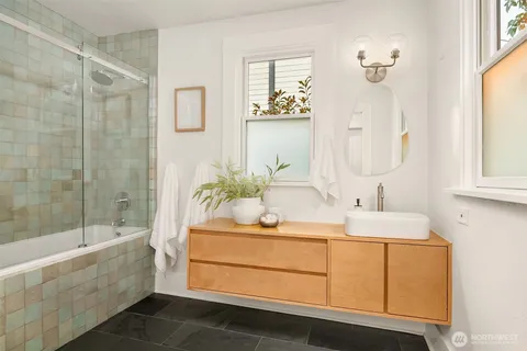 a bathroom with a tub sink and mirror