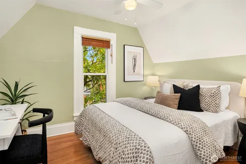 a bedroom with a large bed and a potted plant