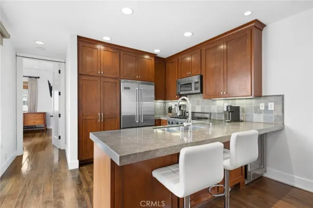 a kitchen with stainless steel appliances granite countertop a refrigerator a sink a stove and oven