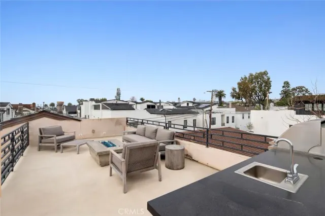 a view of roof deck with couches and sky view