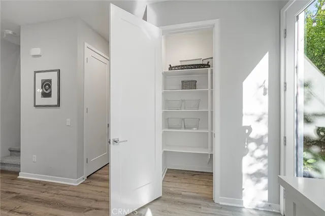 a view of empty room with wooden floor and windows