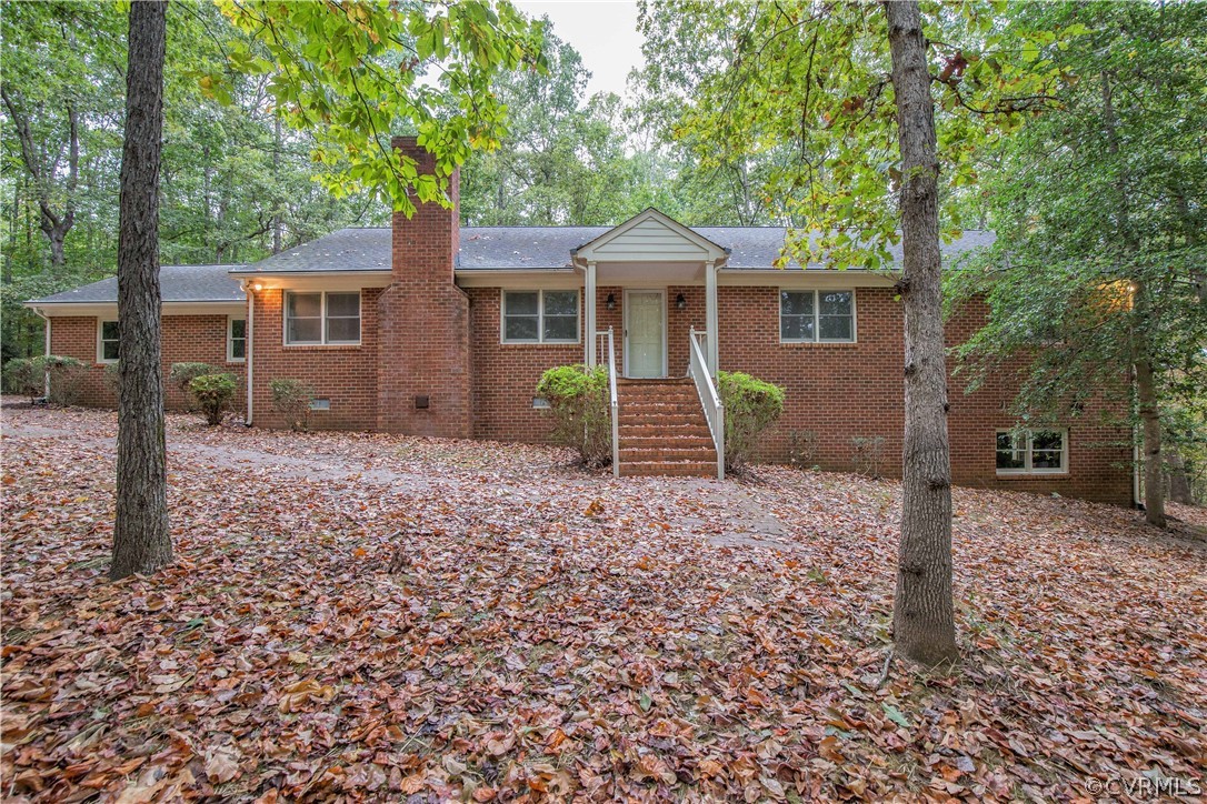 a view of a house with a yard and large tree