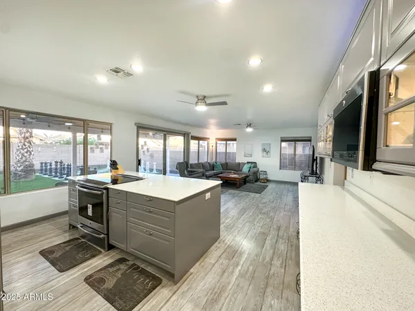 a large kitchen with stainless steel appliances granite countertop a large window and a counter top space