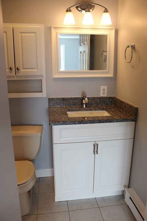 36 C Gibbs Street, Unit 29 Worcester, MA 01607 - Photo 14 of 25 a bathroom with a granite countertop toilet sink and mirror