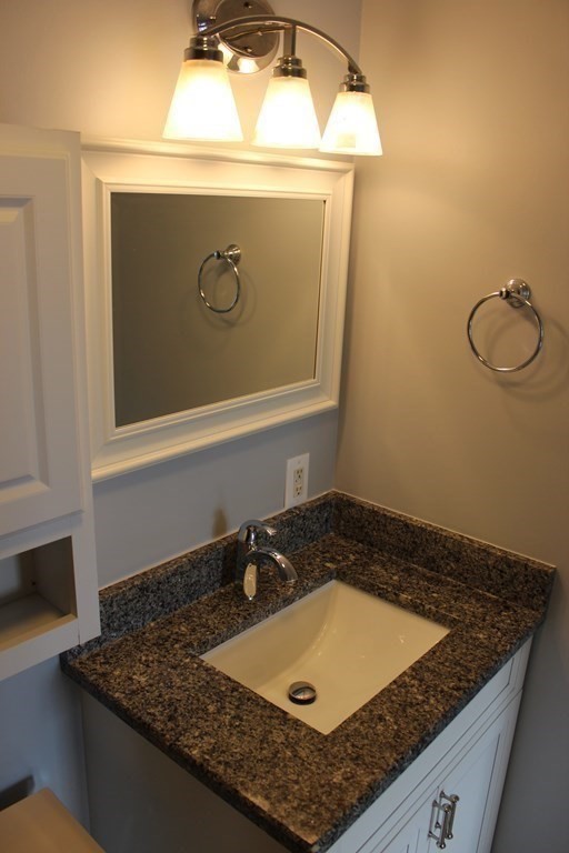 36 C Gibbs Street, Unit 29 Worcester, MA 01607 - Photo 15 of 25 a bathroom with a granite countertop sink and mirror