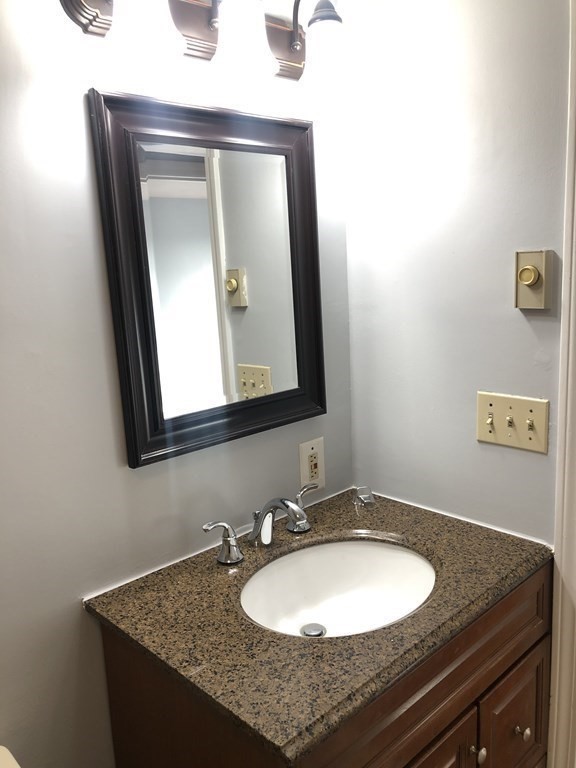 36 C Gibbs Street, Unit 29 Worcester, MA 01607 - Photo 20 of 25 a bathroom with a granite countertop sink and a mirror