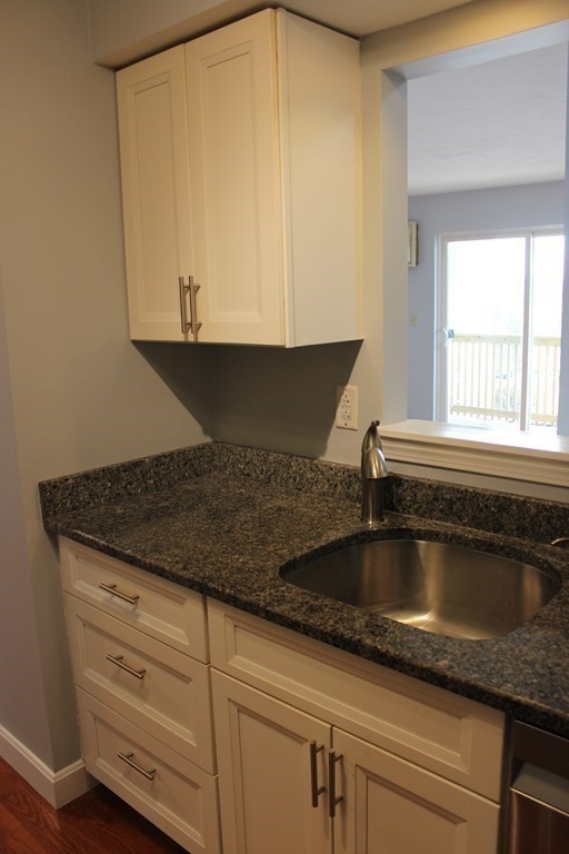 36 C Gibbs Street, Unit 29 Worcester, MA 01607 - Photo 7 of 25 a kitchen with granite countertop a sink and white cabinets