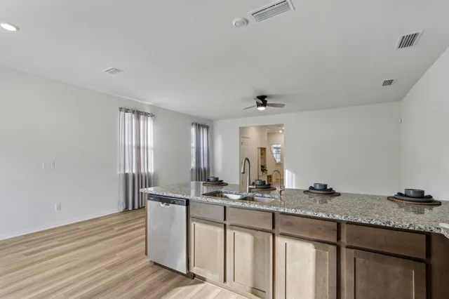 a kitchen with granite countertop a sink and cabinets