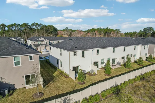 aerial view of a house with big yard and large trees
