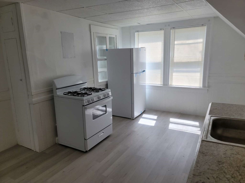 71 Paine Street Worcester, MA 01605 - Photo 14 of 20 a kitchen with granite countertop a refrigerator and a stove