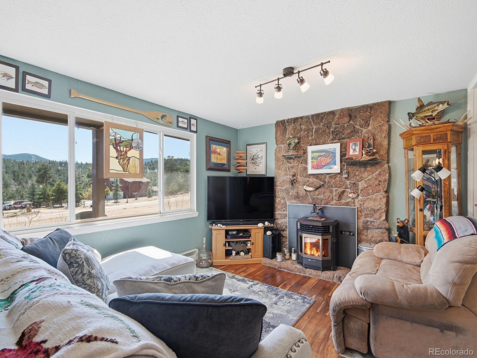 399 Conifer Drive Bailey, CO 80421 - Photo 11 of 42 a living room with fireplace furniture and a flat screen tv
