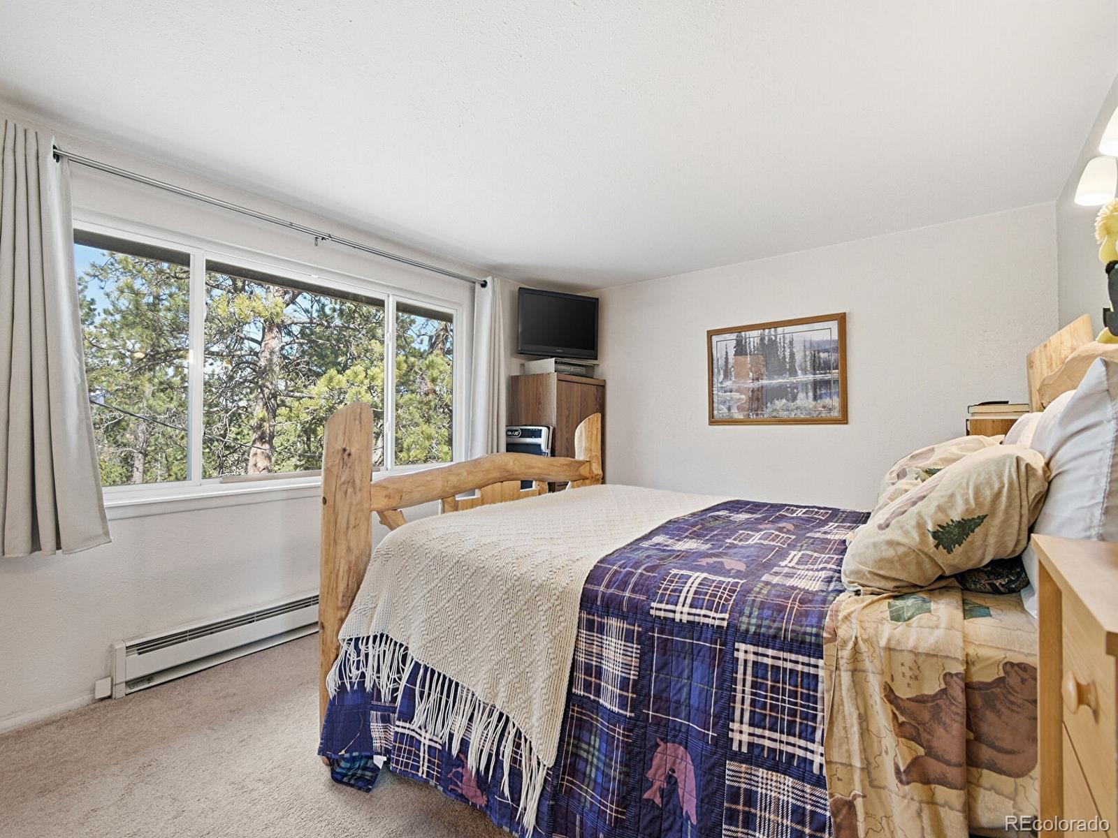 399 Conifer Drive Bailey, CO 80421 - Photo 14 of 42 a bedroom with a bed and wooden floor