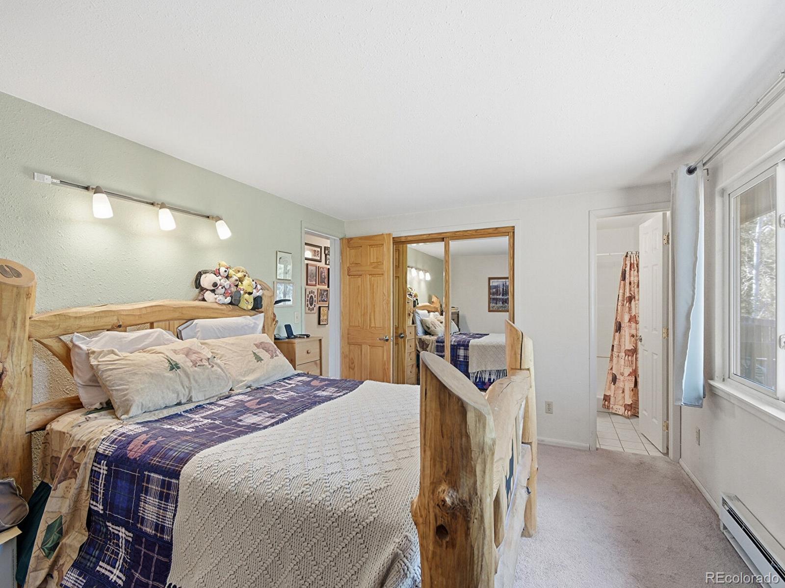 399 Conifer Drive Bailey, CO 80421 - Photo 32 of 42 a bedroom with a bed and a large mirror with the outer view