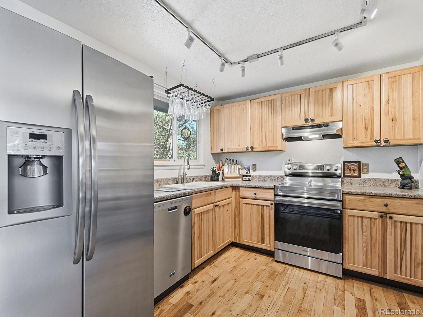 399 Conifer Drive Bailey, CO 80421 - Photo 4 of 42 a kitchen with stainless steel appliances granite countertop a sink a stove a refrigerator cabinets and a window