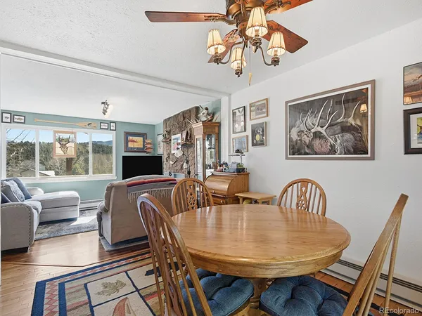 a dining room with wooden floor a chandelier a wooden table and chairs