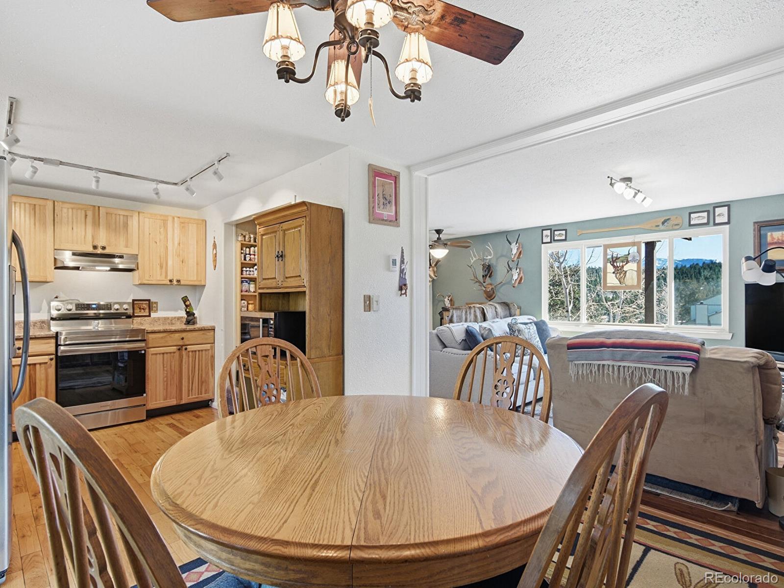 399 Conifer Drive Bailey, CO 80421 - Photo 8 of 42 a dining room with wooden floor a chandelier a wooden table and chairs