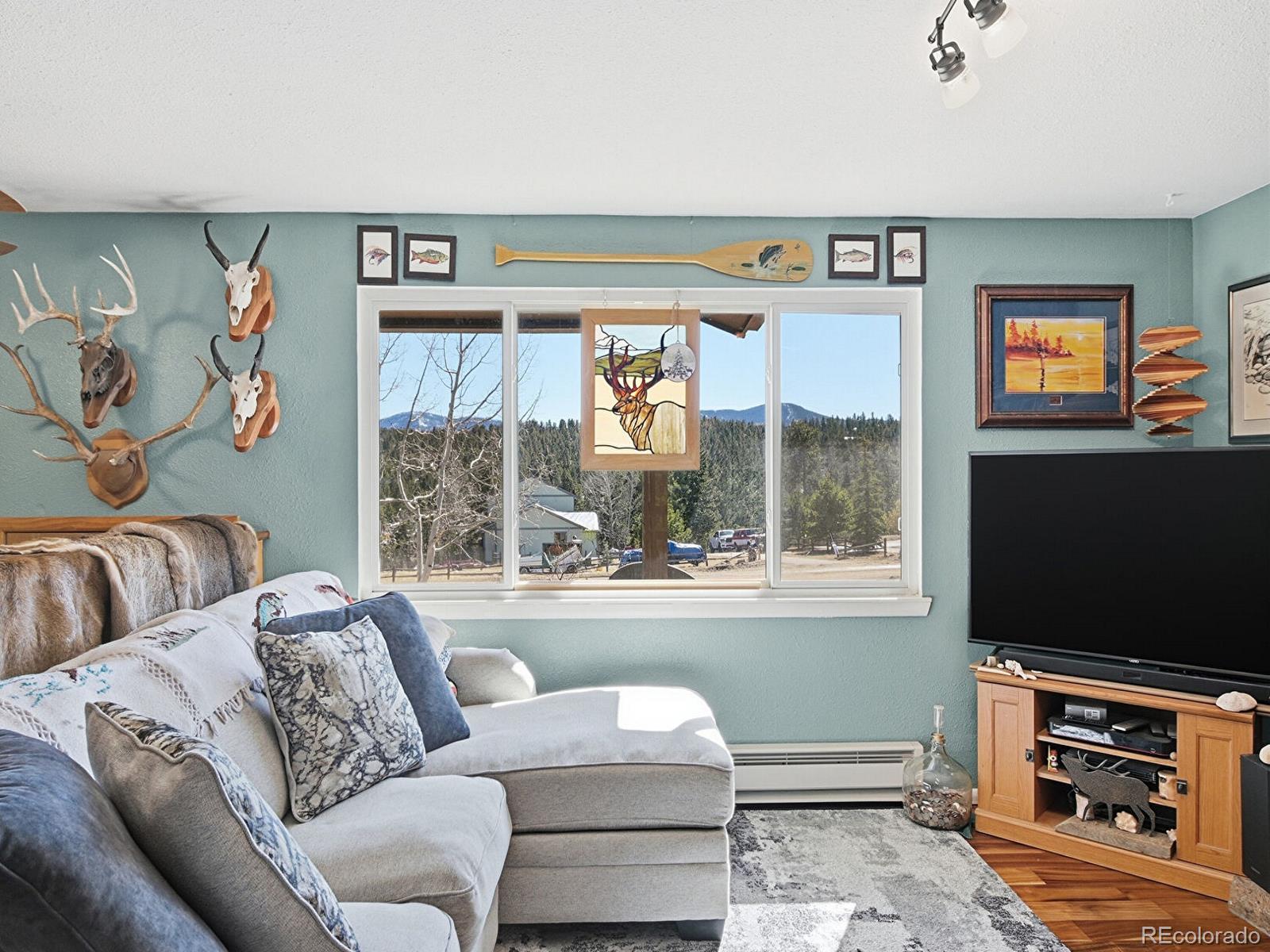 399 Conifer Drive Bailey, CO 80421 - Photo 9 of 42 a living room with furniture a flat screen tv and a floor to ceiling window
