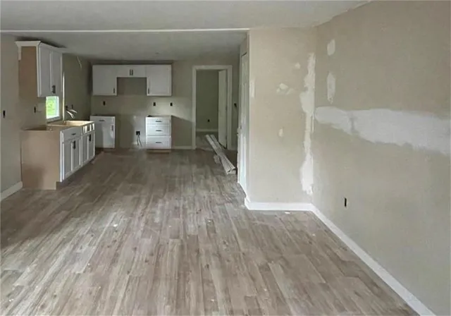 a view of a hallway with wooden floor and a sink