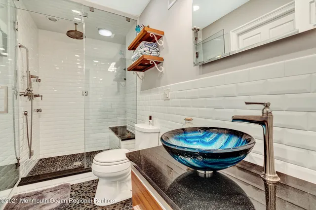 a bathroom with a sink a toilet and a mirror