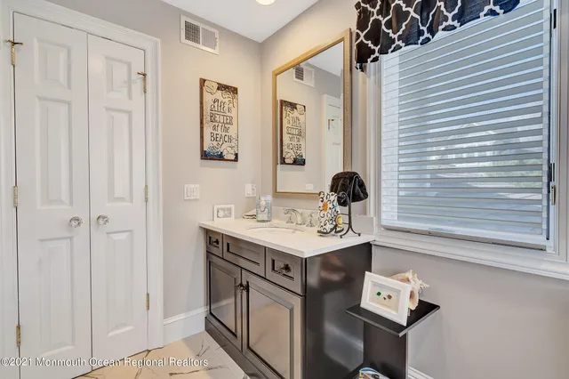 a bathroom with a sink a light fixture and a shower