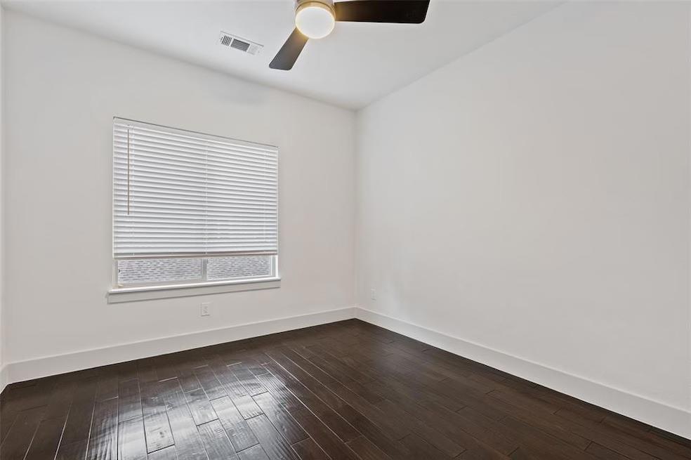 5924 Hudson Street, Unit F Dallas, TX 75206 - Photo 11 of 25 an empty room with wooden floor and windows