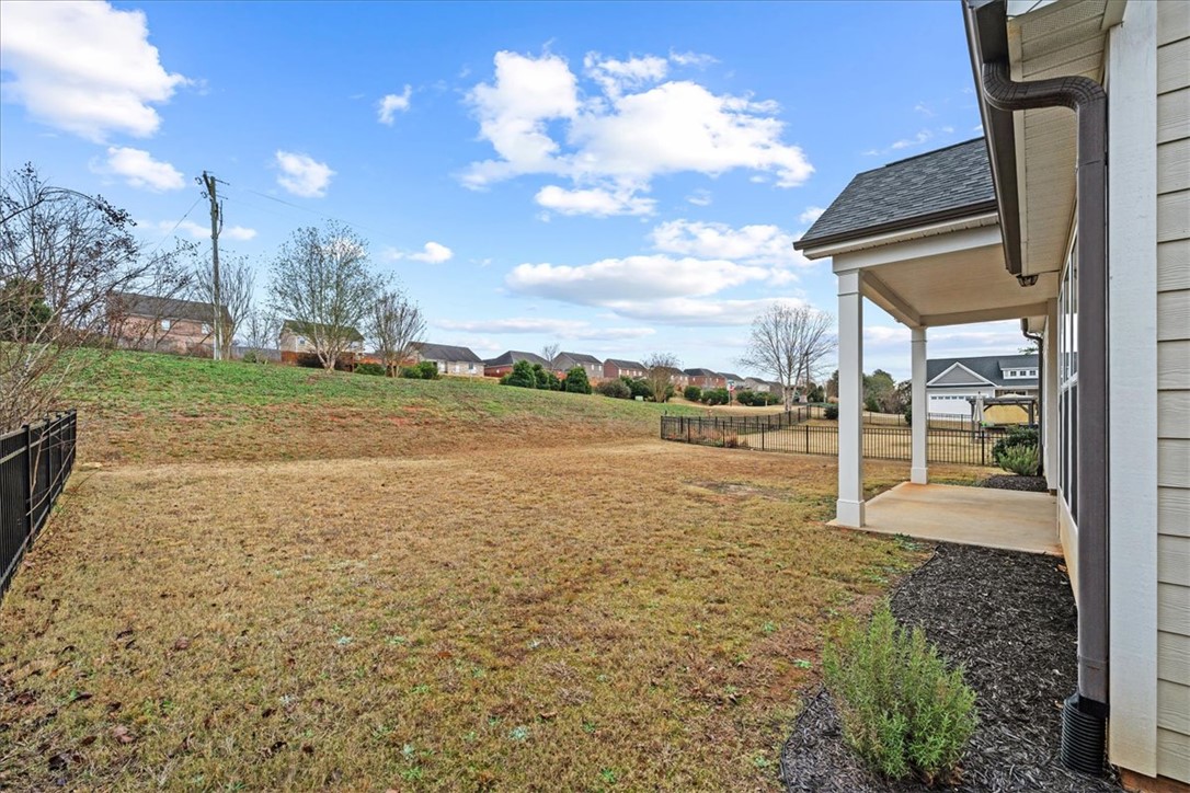 102 Ripplestone Way Anderson, SC 29621 - Photo 35 of 39 A fenced backyard offers a secure and open outdoor space, with a covered porch for leisure.