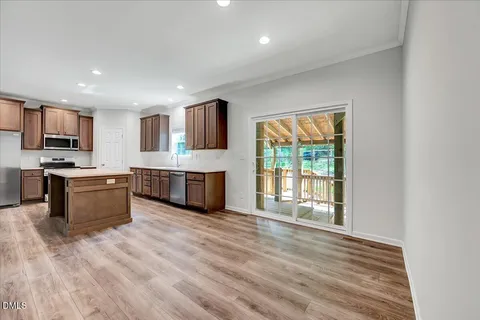 a large kitchen with stainless steel appliances granite countertop a stove a sink and a microwave