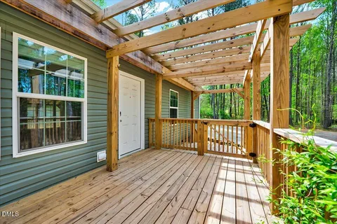 a view of a porch with wooden floor and iron stairs