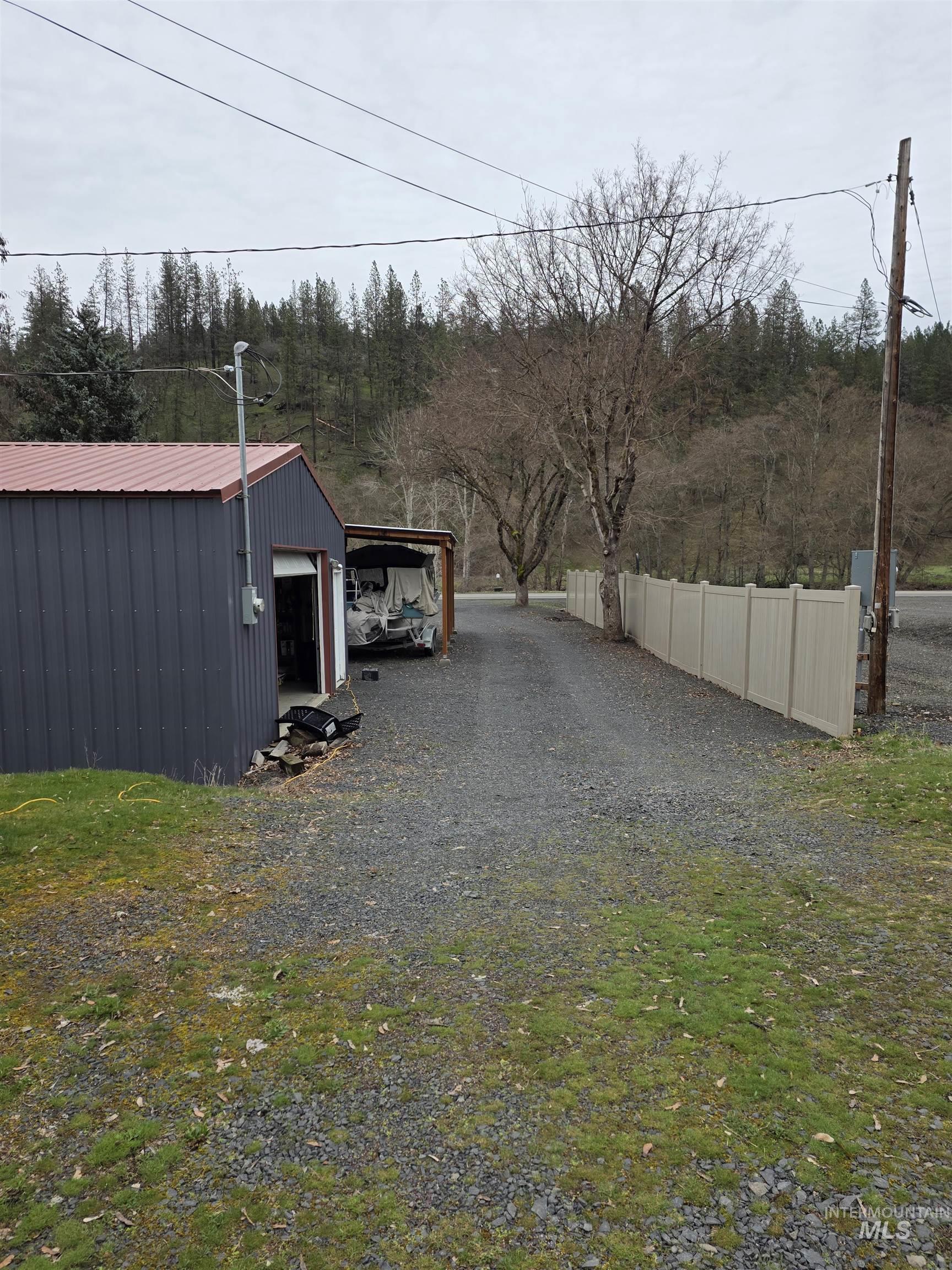 220 South Main Street Peck, ID 83545 - Photo 2 of 15 View of yard with an outbuilding, gravel driveway, and a detached garage