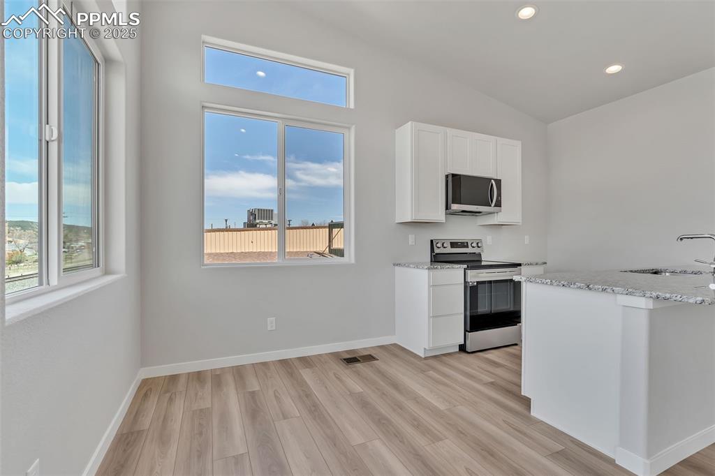 241 Front Street, Unit 103 Monument, CO 80132 - Photo 6 of 28 a kitchen with a refrigerator and a stove top oven