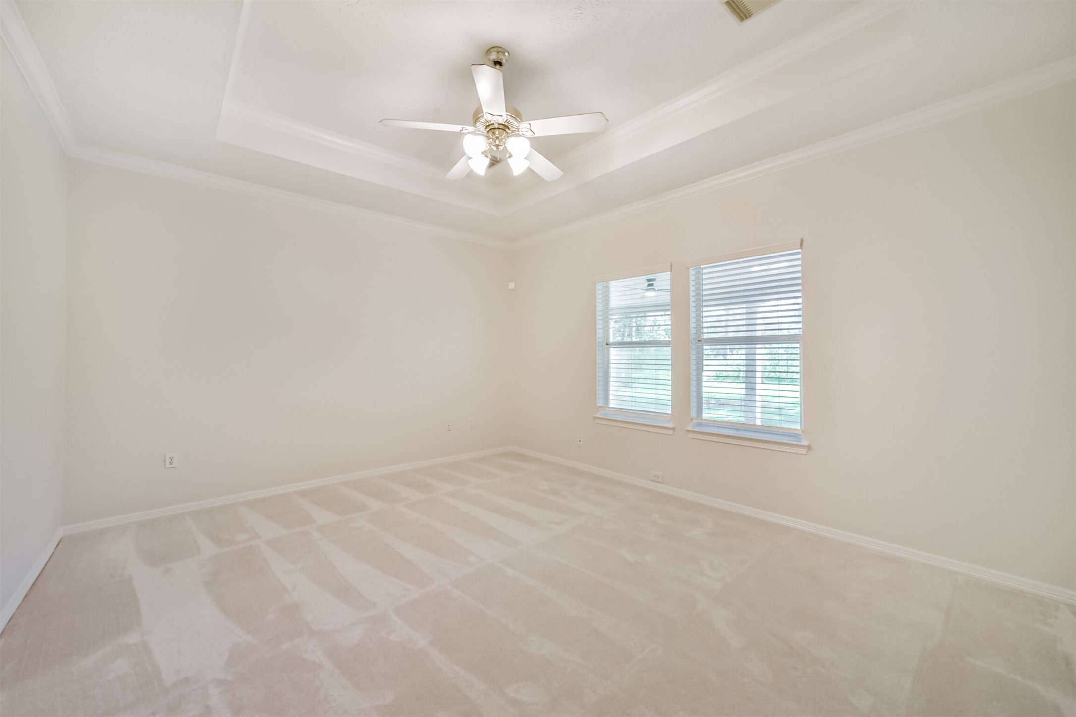 27322 Afton Way Huffman, TX 77336 - Photo 24 of 50 Oversized primary suite features tray ceilings, plush carpeting, and large windows for a peaceful retreat.
