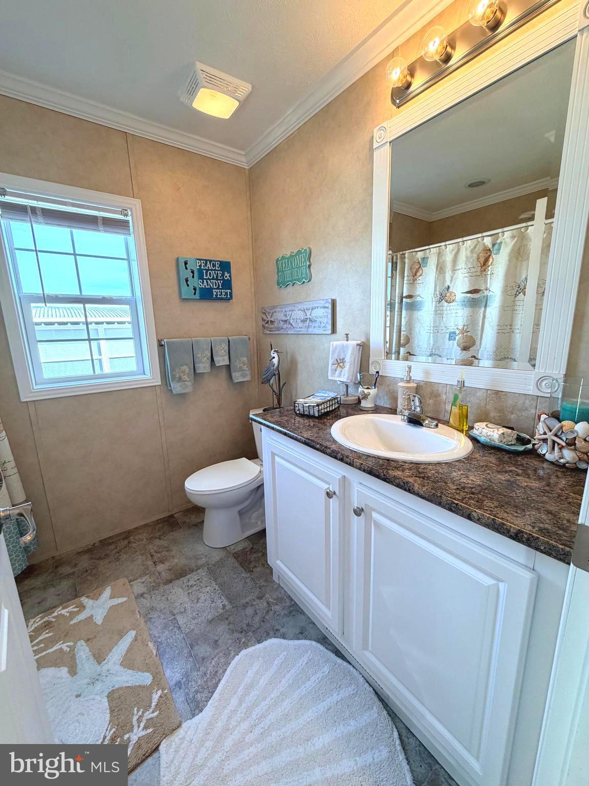 38025 Rabbit Road, Unit 101 Ocean View, DE 19970 - Photo 74 of 112 a spacious bathroom with a granite countertop sink a toilet a mirror and a window
